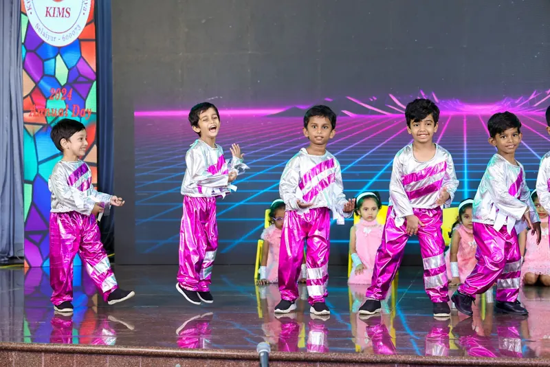 Children in pink and white dance under neon lights