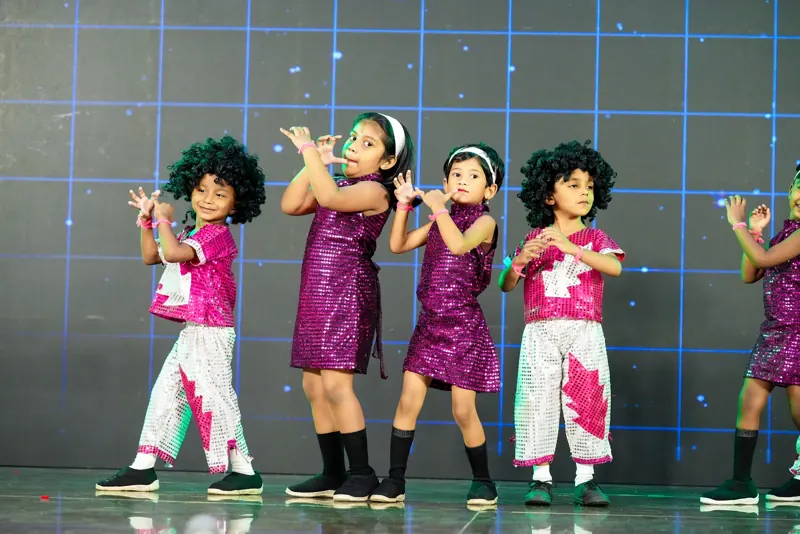 Girls in afro wigs and pink sequins dance