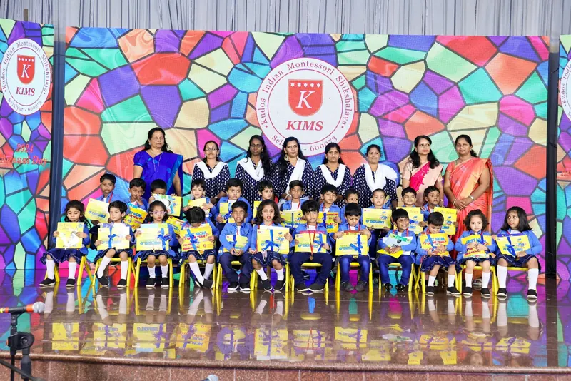 Graduates sit in rows with their certificates and teachers