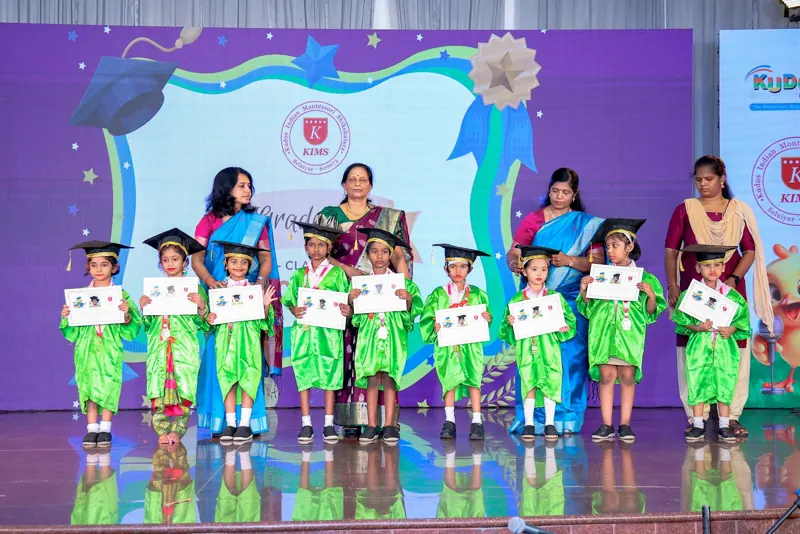 Graduates in caps hold up their certificates with their teachers