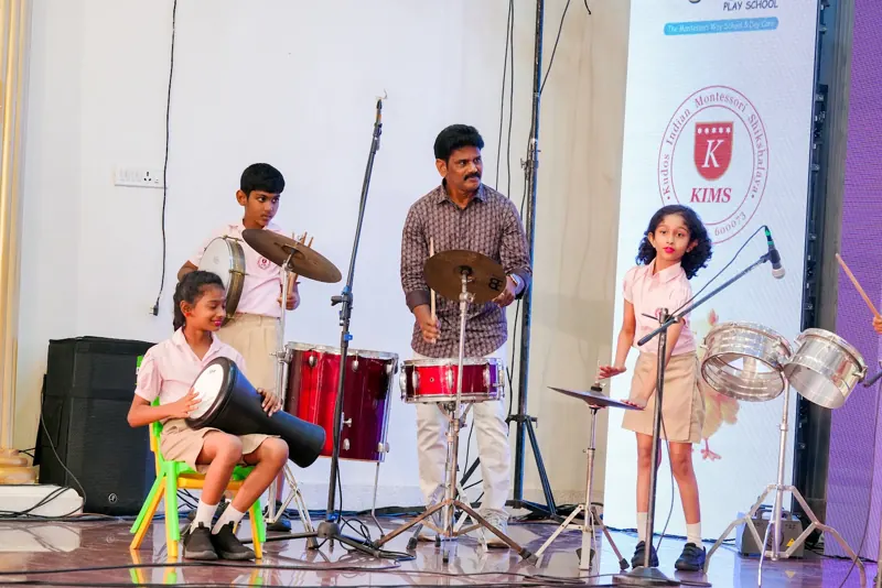 A student band on drums and percussion with the music teacher