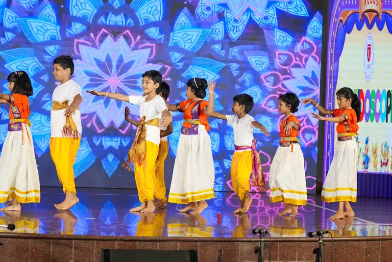 A folk dance in white, yellow and orange costumes