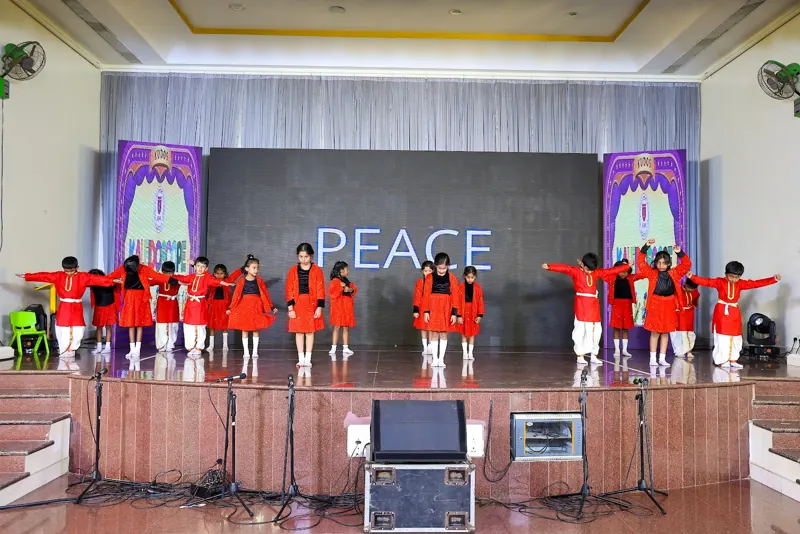 Children in red spell out PEACE on stage