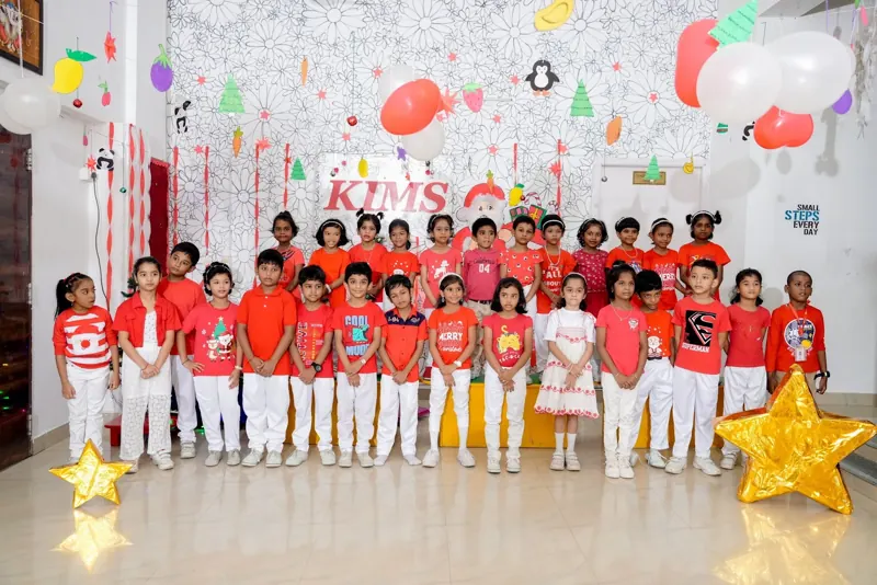 A class in red and white in front of the KIMS Christmas backdrop