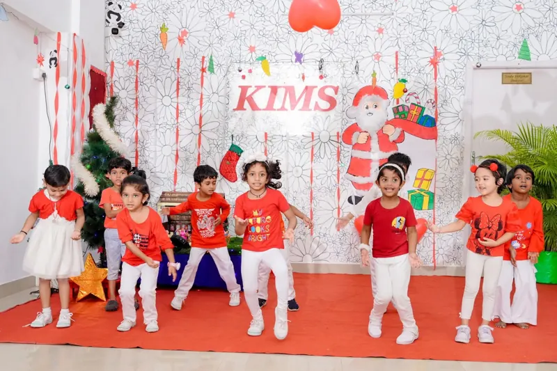Children dance in front of the Christmas set