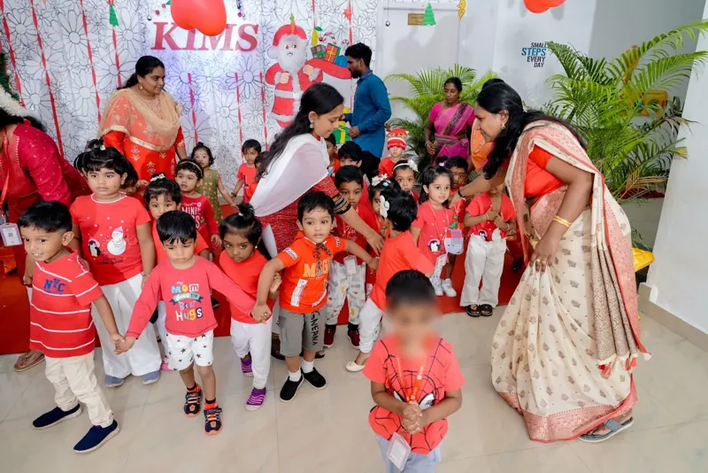 A teacher helps the little ones join the dance