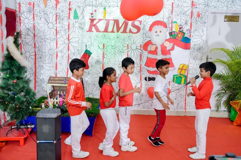 Children sing with a microphone in front of the Christmas set