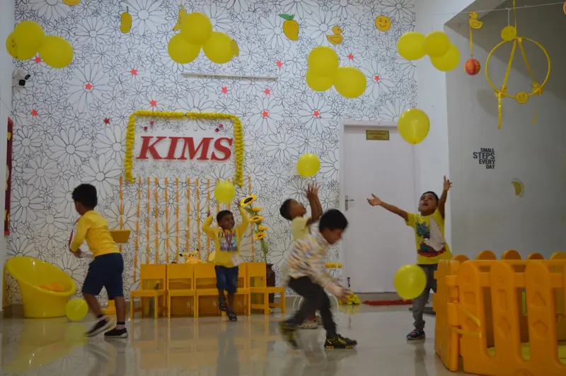 Children chase yellow balloons