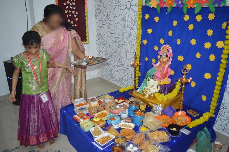 A child brings an offering to the altar with her teachers