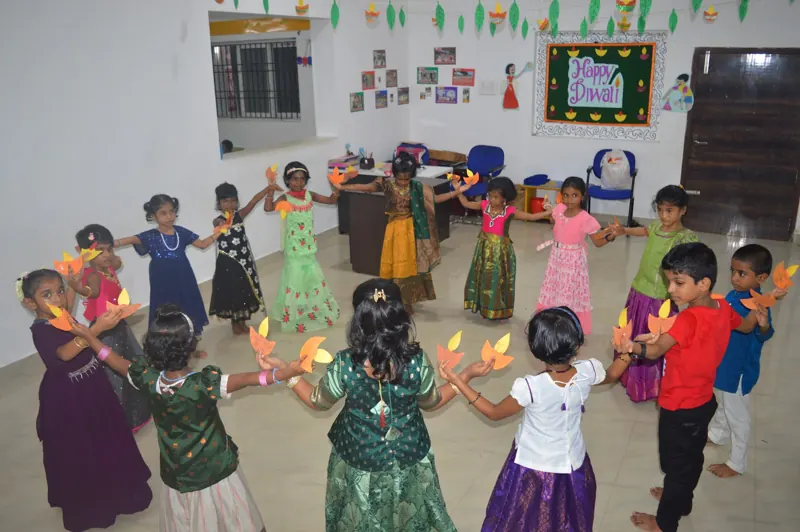 Children dance in a circle with diyas