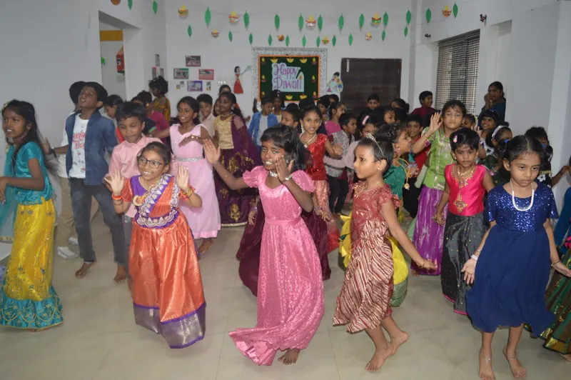 Children in festive clothes dance in the hall