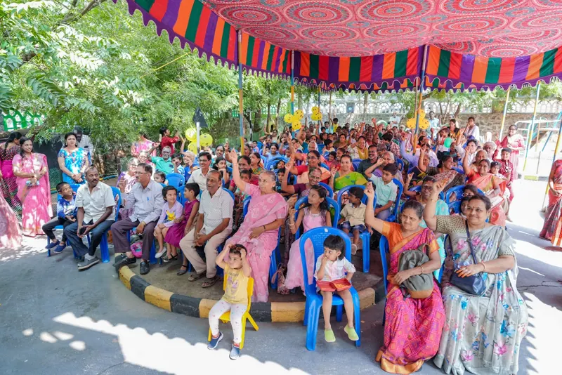 Grandparents fill the courtyard under the festival canopy