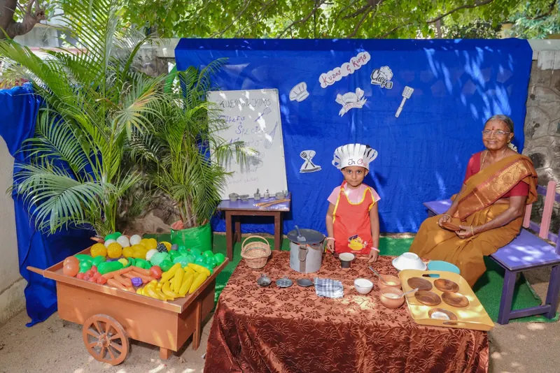 A young chef serves grandparents at the play kitchen