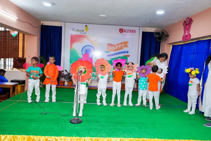 Children in tricolour line up on stage