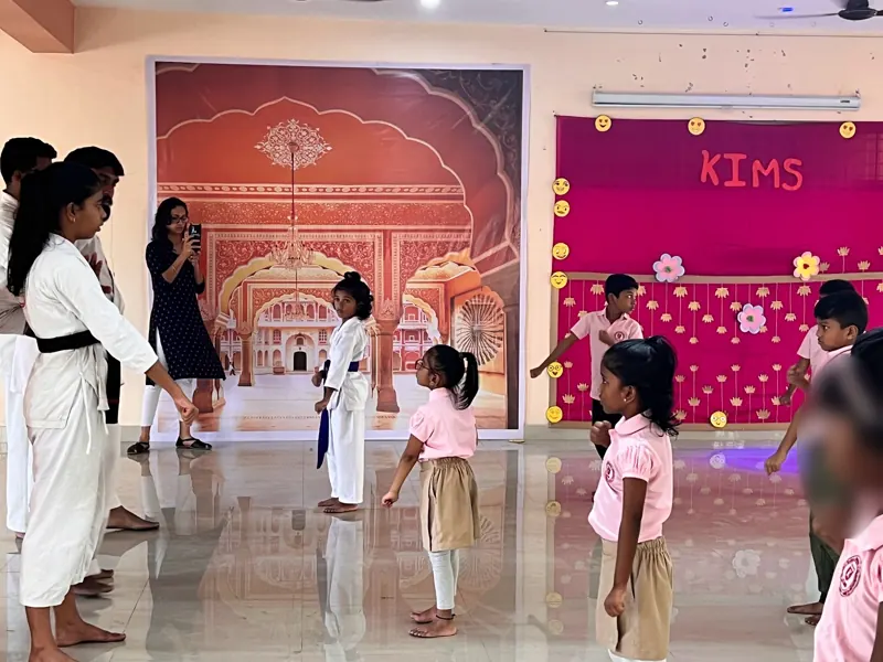 Instructors in white gi with children in the hall