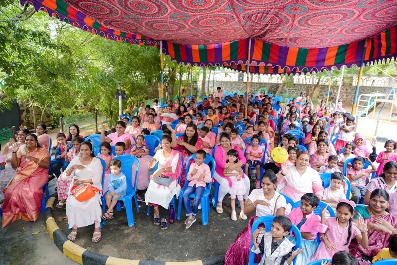 Mothers and children seated under the canopy