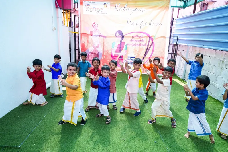 Boys in traditional clothes dance on the turf