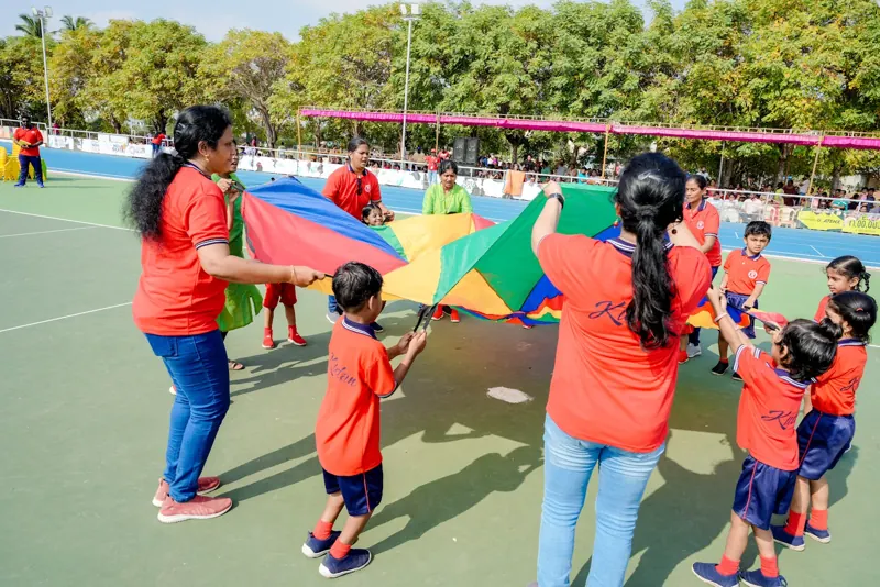 Teachers and children play with a parachute