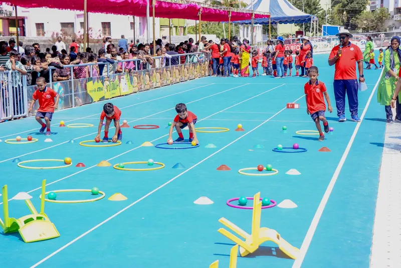 Children run between hoops and cones