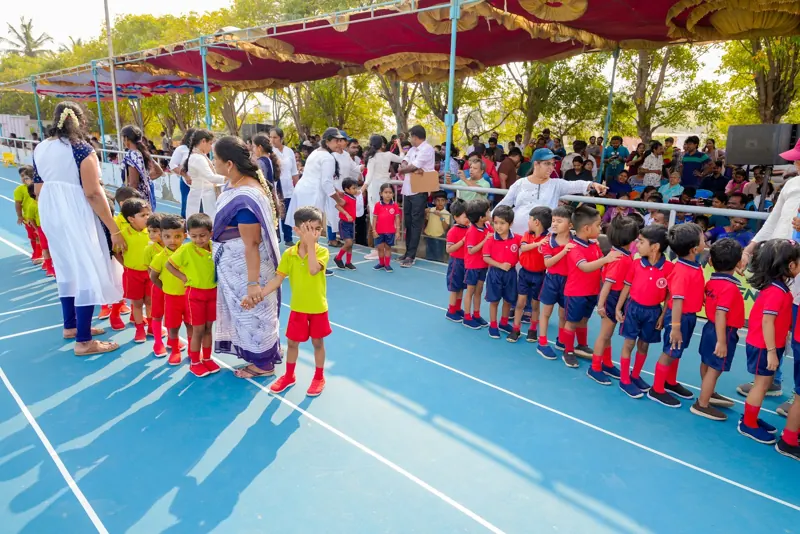 Children line up on the track with their teachers