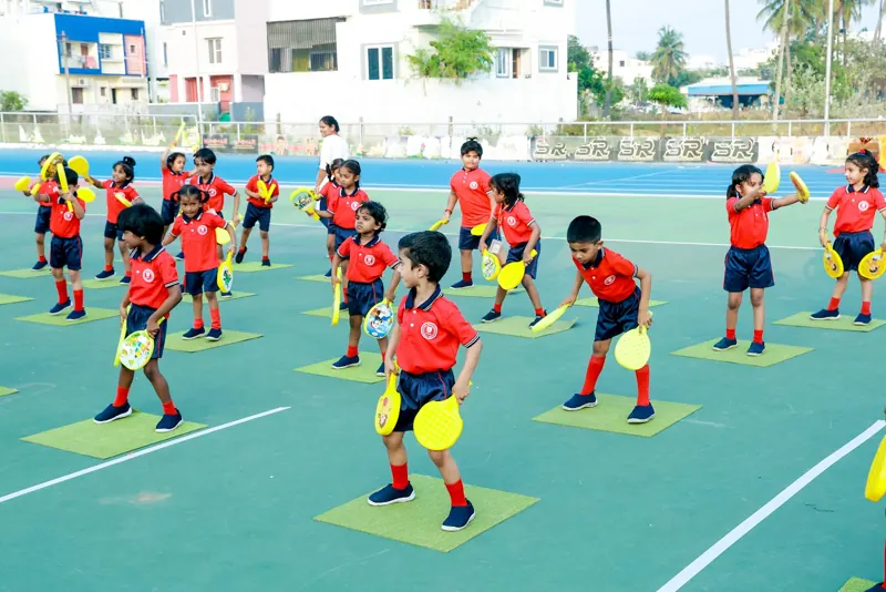 Children perform a drill with yellow discs