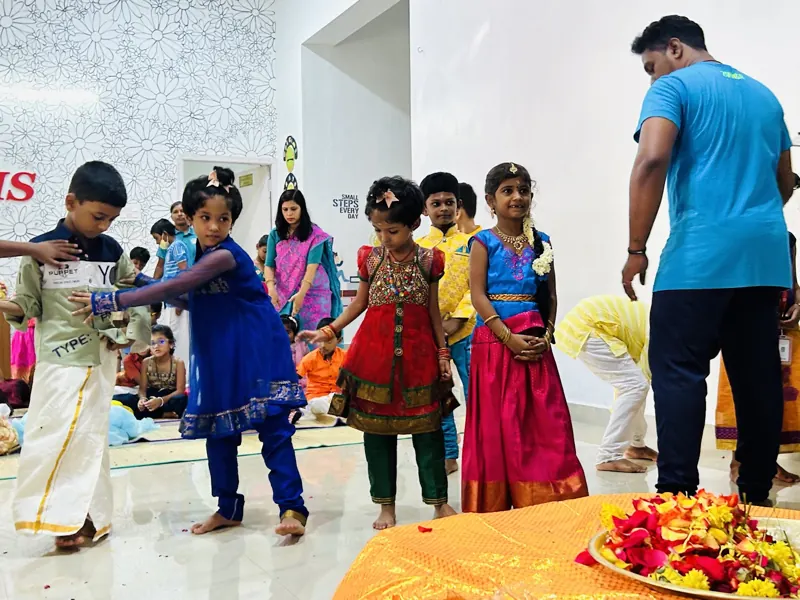 Children in traditional clothes walk up to offer flowers