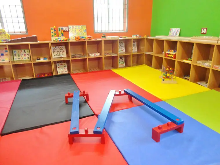 A bright Montessori room with balance beams and open shelves